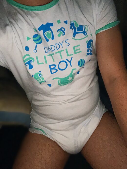 Adult baby boy wearing onesie and diaper